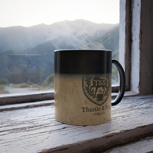 Mug with 'Thistle & Stag' branding on a wooden surface with a mountain view.