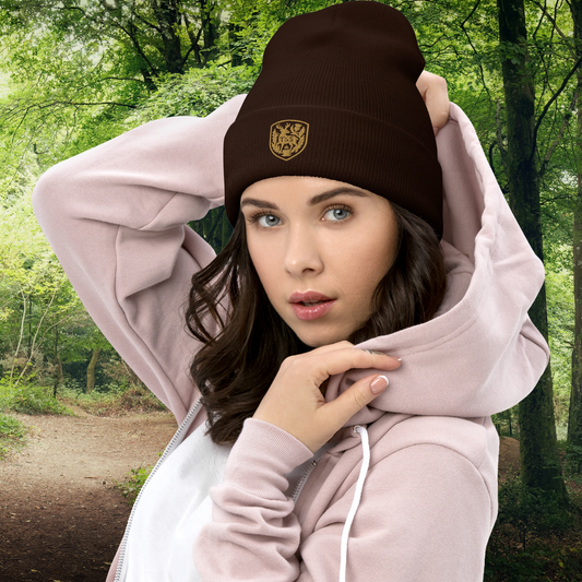 Woman wearing a brown beanie with a Thistle & Stag Coffee Co. logo and pink hoodie in a forest setting