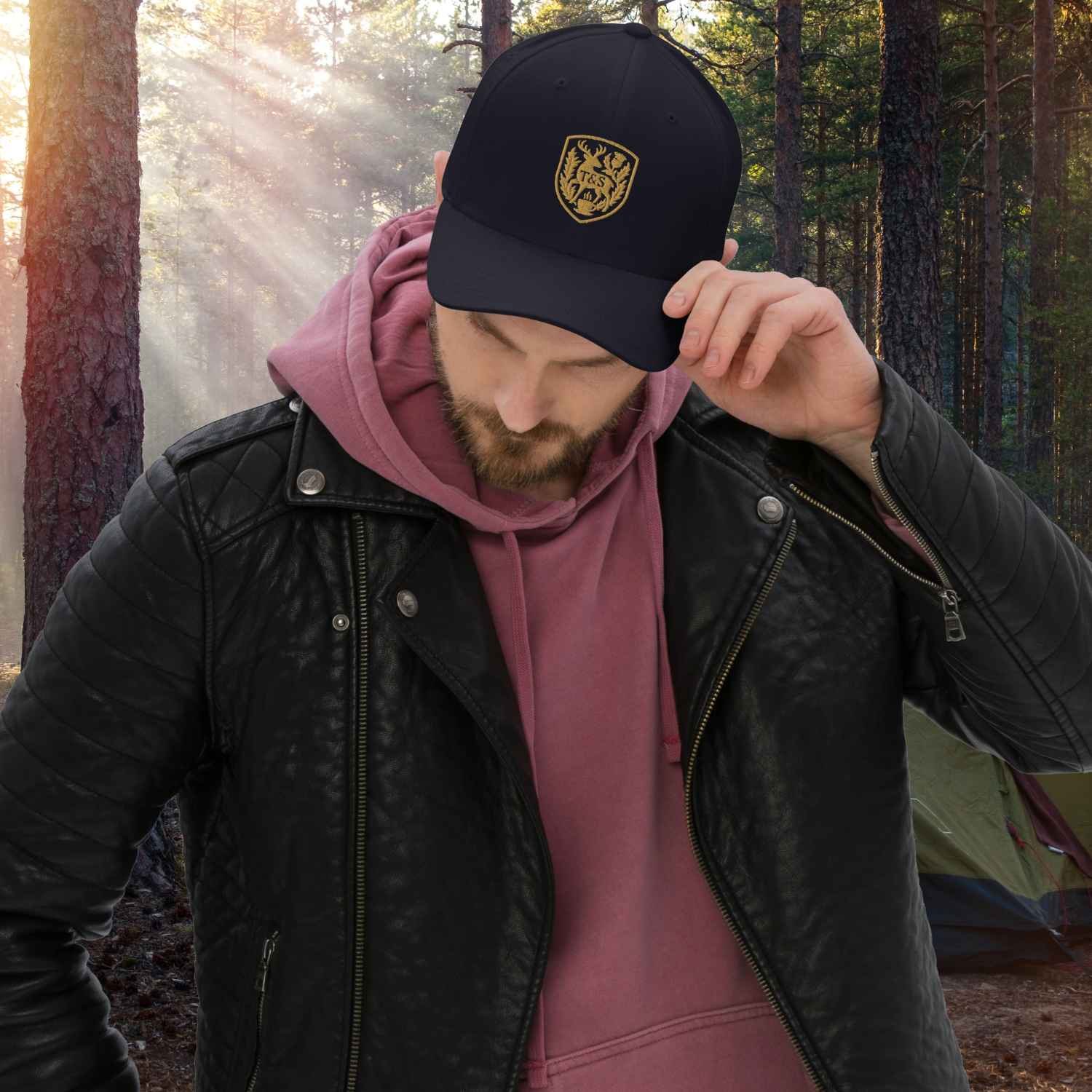 Person wearing a navy blue cap with a Thistle & Stag Coffee Co. logo in a forest setting