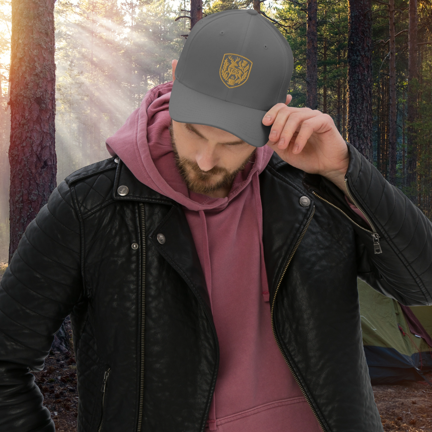 Person wearing a dark gray cap with a Thistle & Stag Coffee Co. logo in a forest setting