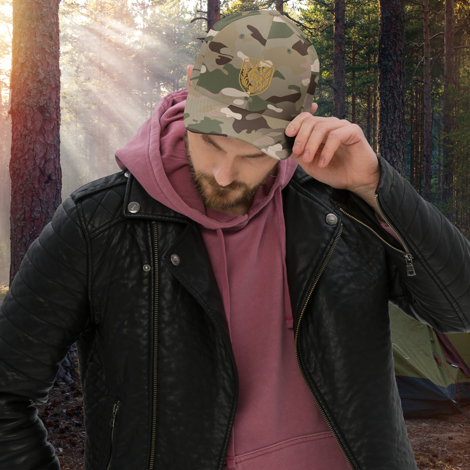 Person wearing a camouflage cap with a Thistle & Stag Coffee Co. logo in a forest setting